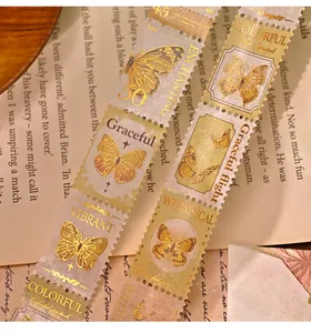 Detaillierte Makroansicht von Vintage-Washi-Tape mit Schmetterlingsstempel und Goldfolie