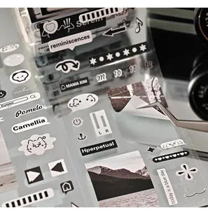 Close-up of monochrome ins style die-cut sticker sheet being peeled with tweezers