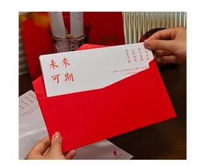 Close-up of hands holding a premium red envelope with an inspirational graduation card