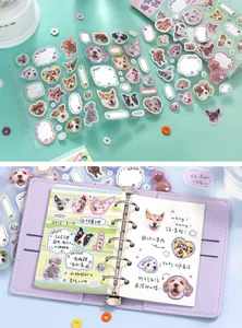 Close-up of cute dog head stickers applied in a purple planner notebook for scrapbooking