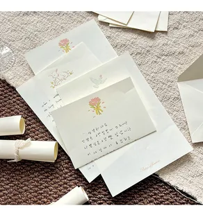 Close-up detail of soft aesthetic stationery set with floral prints and cream envelopes