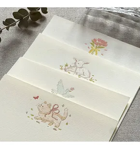 Close-up detail of cream stationery paper set featuring cute hand-drawn animal illustrations