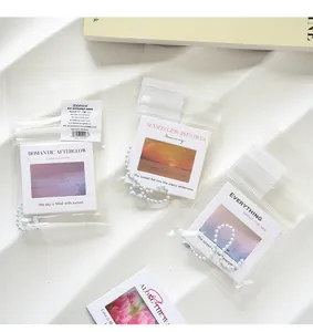 Detail of PET film slide keychains in transparent bags with landscape photos and quotes