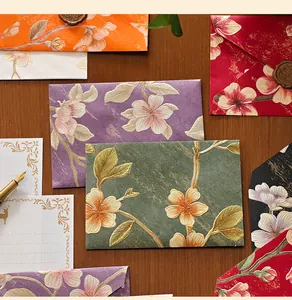 Detail view of vintage embossed envelopes with elegant floral patterns and gold foil accents.
