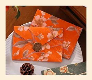 Close-up of vintage orange floral embossed envelope with bronze wax seal decoration