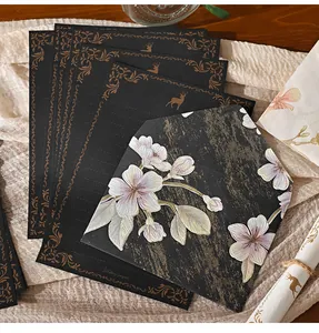 Close-up of vintage black letter paper and embossed floral envelope with gold accents