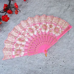 Detailansicht eines eleganten rosa Fächer mit goldenen Spitzenakzenten
