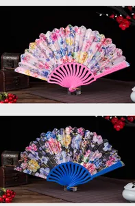Detailed macro view of two elegant floral folding fans with pink and blue frames