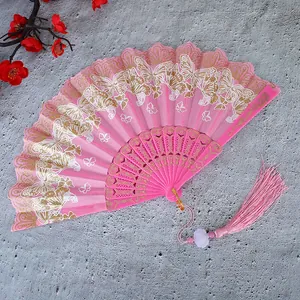Detalle de un abanico plegable chino rosa con estampados de mariposas y una borla colgante.