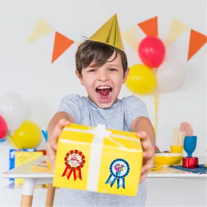 Cheerful child holding a gift box decorated with Happy Birthday award ribbon stickers.