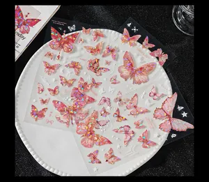 Nahaufnahme von holografischen rosa Schmetterlingsstickern auf einem weißen Teller