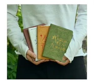 Nahaufnahme von vier bunten A6 Hardcover-Notizbüchern mit eleganter Goldprägung