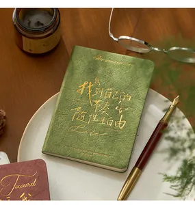Detailansicht eines eleganten grünen A6 Hardcover-Notizbuchs mit Goldfolienprägung