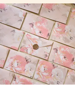 Close-up macro detail of vintage pink floral envelopes featuring elegant gold wax seal finish