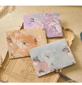Close-up of retro floral envelopes with embossed texture on a vintage tray.