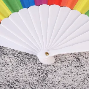Primer plano de las varillas de plástico blanco y la tela de arcoíris de un abanico.
