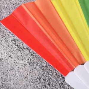 Primer plano de abanico plegable arcoíris que muestra textura de tela y varillas blancas