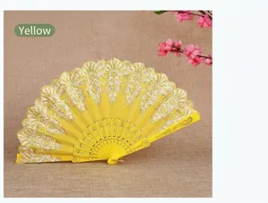 Elegant yellow Chinese folding fan featuring intricate white lace patterns and golden accents