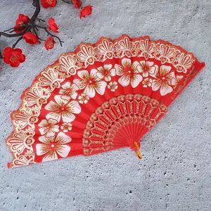 Detailansicht eines roten chinesischen Faltfächers mit eleganten weißen Blumenmustern