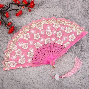 Pink folding fan with white floral lace, hollow handle and tassel for traditional hanfu.