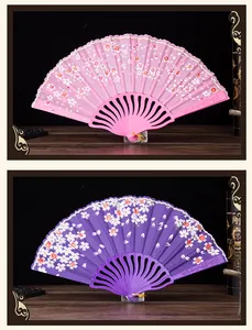 Detailed view of elegant floral folding fans in pink and purple colors for women style