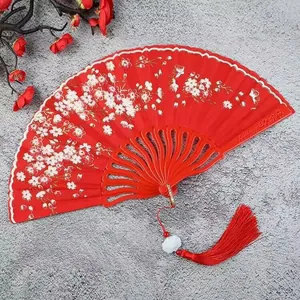 Elegant red folding fan for women featuring delicate white floral patterns and a matching red tassel.
