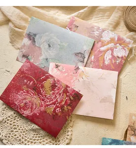 Close-up of vintage oil painting style floral patterns on textured paper envelopes.