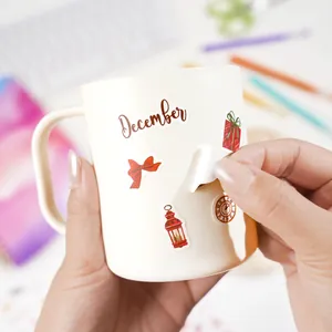 Dettaglio di un adesivo decorativo di dicembre staccato da una tazza in ceramica bianca