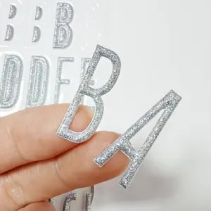 Primer plano de pegatinas de letras 3D con purpurina plateada que muestra textura