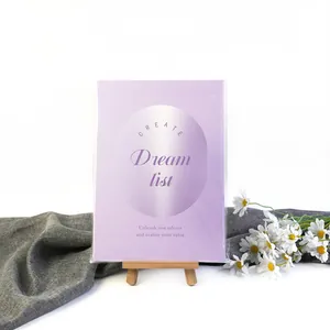 Libro Vision Board morado 'Dream List' en caballete de madera con margaritas blancas