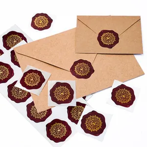 Close-up of vintage burgundy wax seal stickers with gold clock pattern on envelopes