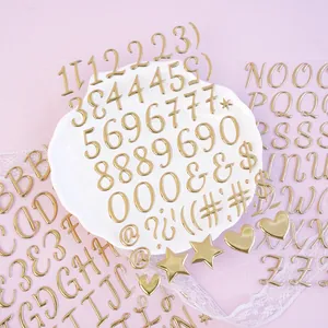 Macro detail of 3D metallic gold bubble stickers featuring letters and numbers for DIY craft