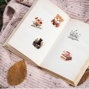 Primer plano de pegatinas de lectura en un cuaderno abierto con una manta rosa