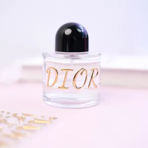 Close-up of 3D metallic gold letter stickers spelling DIOR on a glass bottle