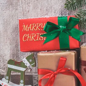 Close-up detail of 3D gold metallic bubble stickers spelling Marry Christmas on gift box
