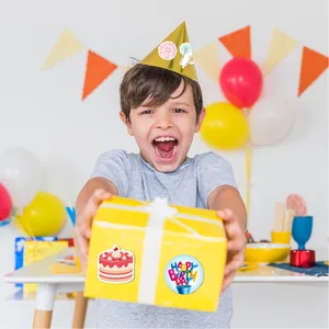 Gros plan de stickers d'anniversaire mignons sur une boîte cadeau jaune de fête d'enfant