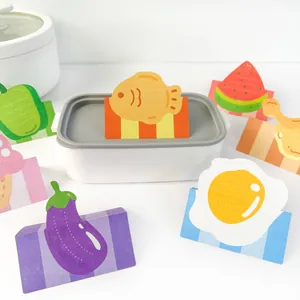 Detail view of cute food-shaped sticky notes with writable lines, egg and fish designs