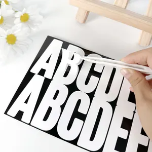 Nahaufnahme von 2,5-Zoll Alphabet-Aufklebern, die mit einer Pinzette abgezogen werden
