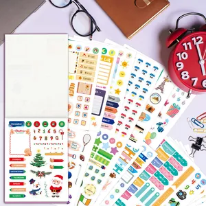 Vista detallada de hojas de pegatinas para agenda con fechas, tareas y temas navideños.