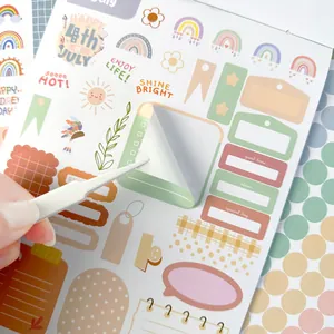 Primer plano de pegatinas Boho para agenda que muestra el adhesivo con una pinza