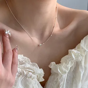 Nahaufnahme einer minimalistischen silbernen AB-Kette mit feinen Perlen am Model