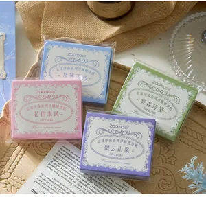 Four packs of vintage floral embossed memo pads displayed on a rustic wooden tray