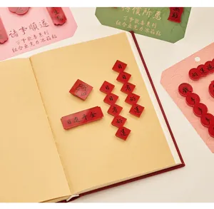 Close-up of red acrylic refrigerator magnets with Chinese calligraphy on an open notebook.