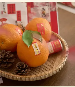 Autocollants de bénédiction chinoise en feuille d'or sur des oranges dans un panier