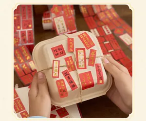 Gros plan d'autocollants de bénédiction chinois en feuille d'or rouge sur une boîte