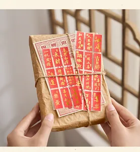 Gros plan d'autocollants de bénédiction chinoise dorés sur un paquet cadeau en papier