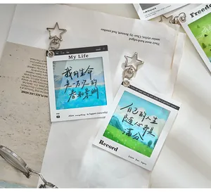 Close-up of PET photo frame keychain with scenic landscape illustrations and inspirational text.