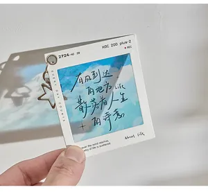 Close-up of a PET film keychain featuring artistic calligraphy and a metal star charm