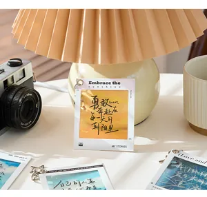 Close-up view of a PET film sheet keychain with motivational text under a warm lamp