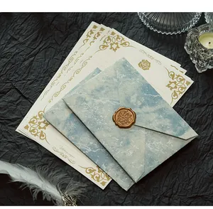Nahaufnahme eines blauen Marmorumschlags mit goldenem Wachssiegel und Zierpapier